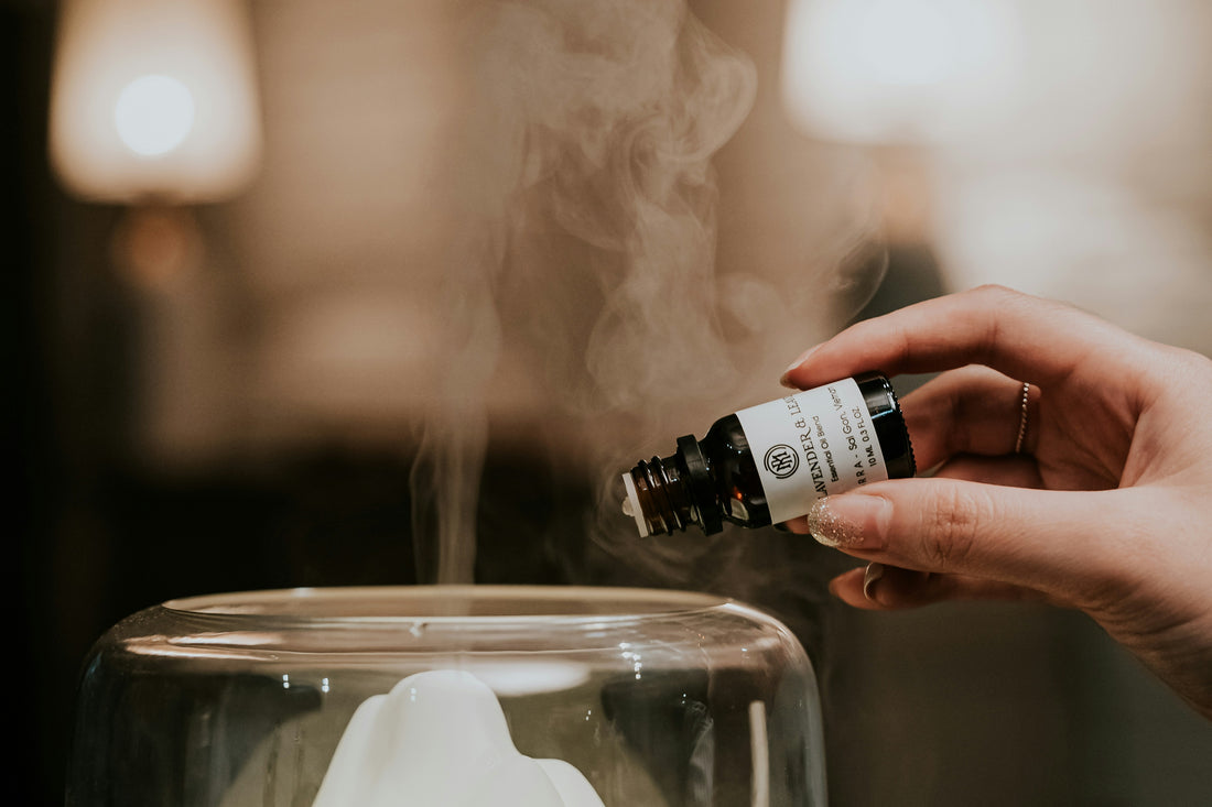 Female hand putting essential oils into a diffuser